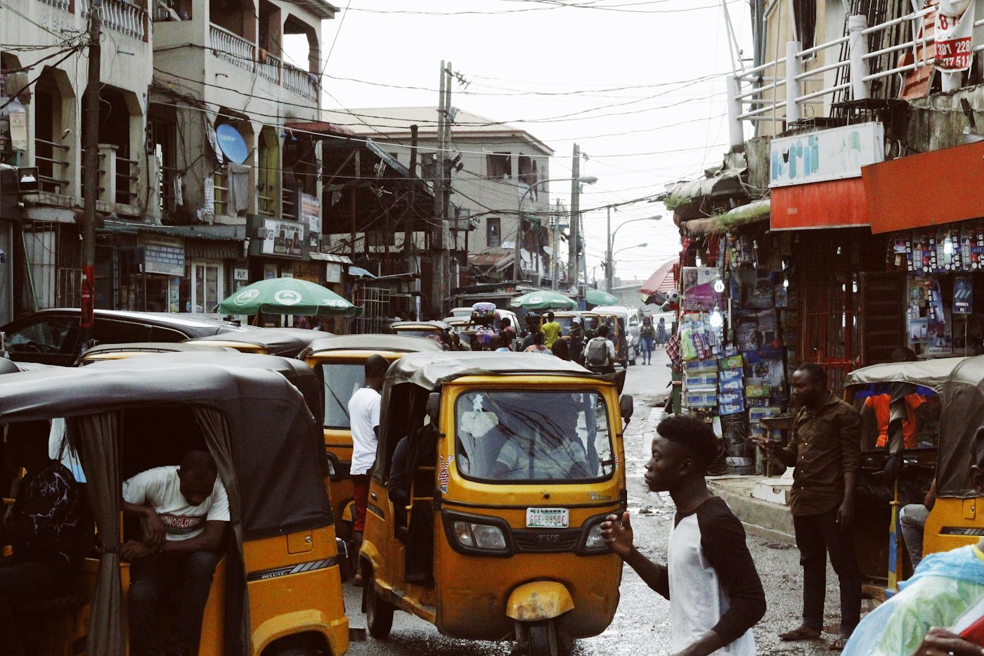 A busy street market with tricycles and traders